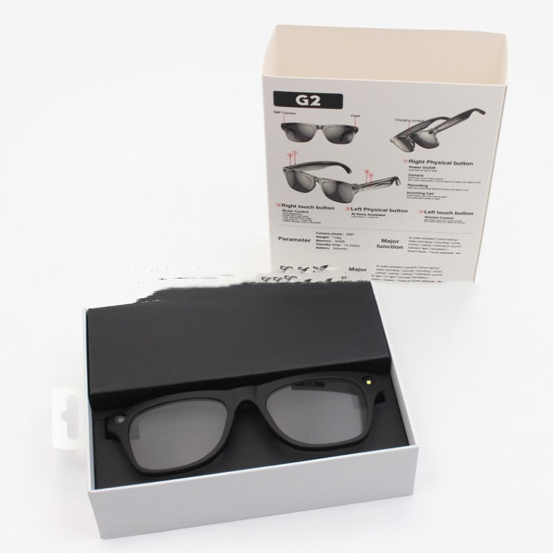 Black sunglasses in an open box with a product information sheet on a white background